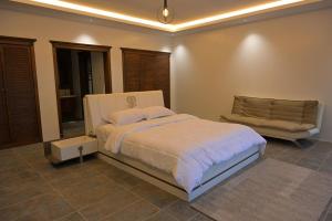 a bedroom with a large bed and a couch at منتجع بيت الريف in Al Hofuf