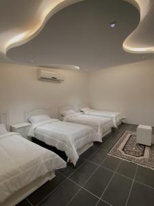 un grupo de camas en una habitación con techo en منتجع بيت الريف, en Al Hofuf