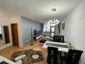 a living room with a couch and a dining room at Luxury Apartament in "Sequoia" 2 in Borovets