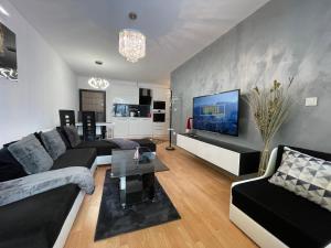 a living room with a couch and a tv at Luxury Apartament in "Sequoia" 2 in Borovets
