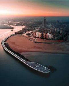 a bridge over the water next to a beach at Comfort Aan Zee Guestrooms in Ostend