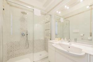 biała łazienka z prysznicem i umywalką w obiekcie Residenza Astra w Weronie