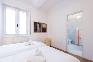 維洛納的住宿－Residenza Astra，一间白色卧室,配有两张床和镜子