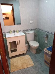bagno con servizi igienici, lavandino e specchio di APARTAMENTO CANELAS a Portonovo