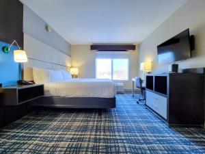 a hotel room with a bed and a flat screen tv at Holiday Inn - Belcamp - Aberdeen Area, an IHG Hotel in Belcamp