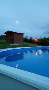 a blue swimming pool with a house in the background at Casatorre Castagnedola in Zocchetta
