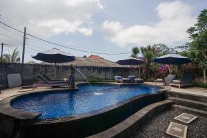 a swimming pool with a statue in a yard at Abian Cottage Lembongan in Nusa Lembongan