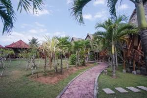 een loopbrug voor een resort met palmbomen bij Abian Cottage Lembongan in Nusa Lembongan