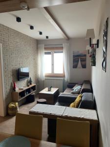 ein Wohnzimmer mit einem Sofa, einem Bett und einem Tisch in der Unterkunft Apartment Župa 111, Župa Wellness & Spa, Kopaonik in Kopaonik