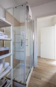 Habitación con ducha de cristal y suelo de madera. en La Casa del Sarto - Rooms and Apartments en Lecco