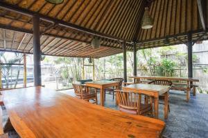 een eethoek met houten tafels en stoelen bij Abian Cottage Lembongan in Nusa Lembongan