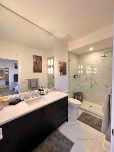 een badkamer met een wastafel, een toilet en een douche bij Lake Okanagan Oasis - Rooftop Patio in West Kelowna