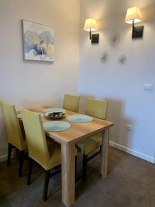 a dining room with a wooden table and chairs at Apartment Župa 111, Župa Wellness & Spa, Kopaonik in Kopaonik +20 photos