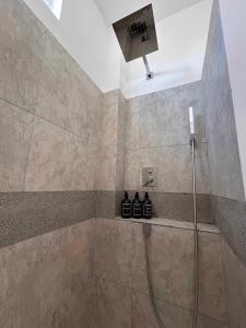 ein Bad mit einer Dusche mit einem Duschkopf in der Unterkunft Yellow Heron House in Puerto Villamil