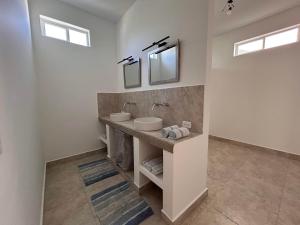 ein Badezimmer mit zwei Waschbecken und zwei Spiegeln in der Unterkunft Yellow Heron House in Puerto Villamil