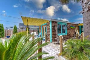 a small house on the beach with a fence at Cape Fear at Island Breeze of CB in Carolina Beach +13 photos