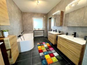 ein Badezimmer mit einer Badewanne, 2 Waschbecken und einer Badewanne in der Unterkunft Ferienhaus Lieblingsplatz in Blaibach
