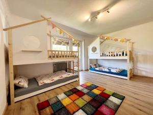 2 Kinderzimmer mit Etagenbetten und einem Teppich in der Unterkunft Ferienhaus Lieblingsplatz in Blaibach