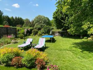 twee stoelen en een tafel in de tuin bij maison avec beau jardin arboré in Torcy