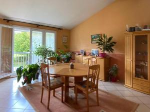een eetkamer met een houten tafel en stoelen bij maison avec beau jardin arboré in Torcy