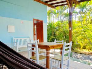 a dining room with a table and chairs on a porch at Pousada la Boheme Guarda do Embaú - SC in Guarda do Embaú