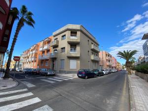 un bâtiment dans une rue avec des voitures garées dans la rue dans l'établissement Casa Antonio - apartamento Luna, à Playa de San Juan