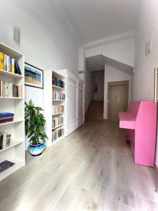 Casa Antonio - apartamento Luna في بلايا دي سان خوان: غرفة معيشة مع مكتب وردي وأرفف كتب