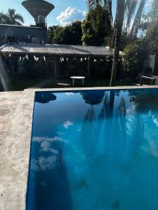 a swimming pool with blue water in a yard at Casa de Huéspedes La Escondida in Yerba Buena