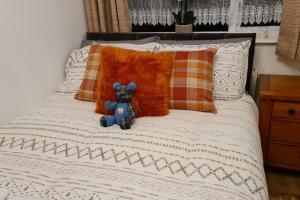 a teddy bear sitting on top of a bed at Northlea-Scottish style cottage in Inverness