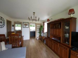 a living room and dining room with a dining table and a television at Northlea-Scottish style cottage in Inverness