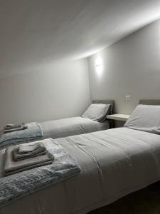 ein Schlafzimmer mit 2 Betten und Handtüchern darauf in der Unterkunft DR HOUSE in Airola