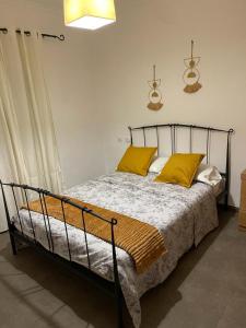 ein Schlafzimmer mit einem Bett mit gelben Kissen darauf in der Unterkunft UIM Mediterraneo PB Miguel Hernandez Wifi in Puerto de Sagunto + 4 Fotos