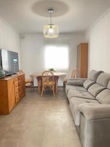 a living room with a couch and a table at UIM Mediterraneo PB Miguel Hernandez Wifi in Puerto de Sagunto +5 photos