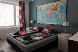 a room with two beds with a map on the wall at Joensuun kalastajan helmi in Joensuu