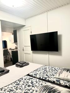 a bedroom with a bed with a flat screen tv on the wall at Pronssi Villa in Vuokatti