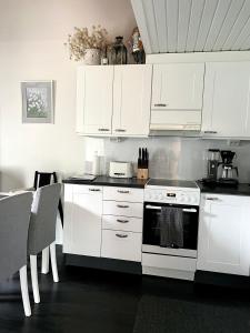 uma cozinha com armários brancos e um fogão branco em Pronssi Villa em Vuokatti