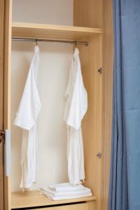 two towels are hanging on a shelf in a bathroom at BeHomu Apartments in Kira