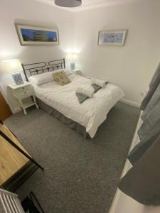 ein Schlafzimmer mit einem Bett und einem Tisch mit einer Lampe in der Unterkunft The Nest at Wynncroft in Torquay