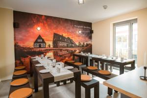 a dining room with tables and a painting on the wall at ELLY Hostel in Freiberg