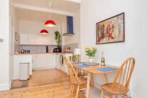 a kitchen and dining room with a table and chairs at Vibrant and Spacious 2BD flat for 4 in Edinburgh in Edinburgh