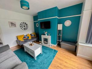 ein Wohnzimmer mit einem Sofa und einer blauen Wand in der Unterkunft HILLTOP PLACE SUITES , Parkway M1 J33 in High Hazels