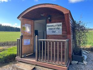 una casa exterior de madera con un cartel en ella en Willow Straw Bale Cabin, 