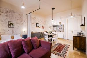 sala de estar con sofá púrpura y cocina en BudapeStayz - Erkel Studios en Budapest