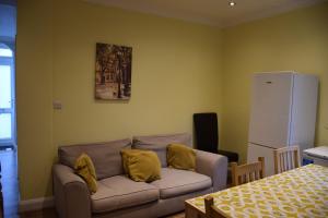 a living room with a couch with yellow pillows at Three Bedroom House Lancaster Road in London