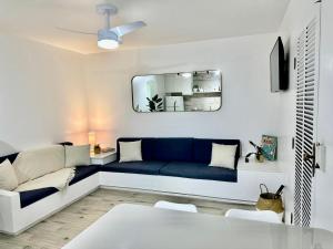 ein Wohnzimmer mit einem blauen Sofa und einem Spiegel in der Unterkunft Apartamento estilo Chalé com piscina in Ubatuba