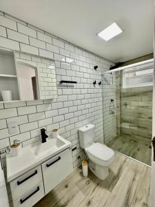 y baño con aseo, lavabo y ducha. en Apartamento estilo Chalé com piscina, en Ubatuba