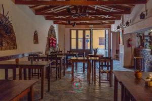 a restaurant with wooden tables and chairs in a room at Hotel Cactus Plaza in Purmamarca