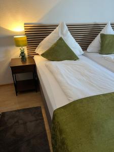 una camera d'albergo con letto con cuscini verdi e bianchi di Pension Stadt Mannheim a Mannheim