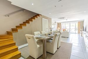 a dining room with a table and chairs and a staircase at Large Luxury apartment on Palm Beach in Palm-Eagle Beach