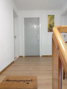 una alfombra de bienvenida frente a una puerta en una habitación vacía en Landcafe SIMA & Zimmervermietung en Forheim